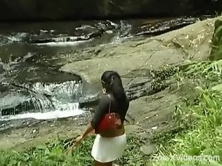 Latina rides a dog's dick by a beautiful waterfall